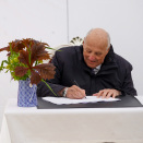 Kong Harald og Dronning Sonja signerer på et eget papir. Senere skal navnetrekkene overføres til Kongesteinen. Foto: Liv Anette Luane, Det kongelige hoff